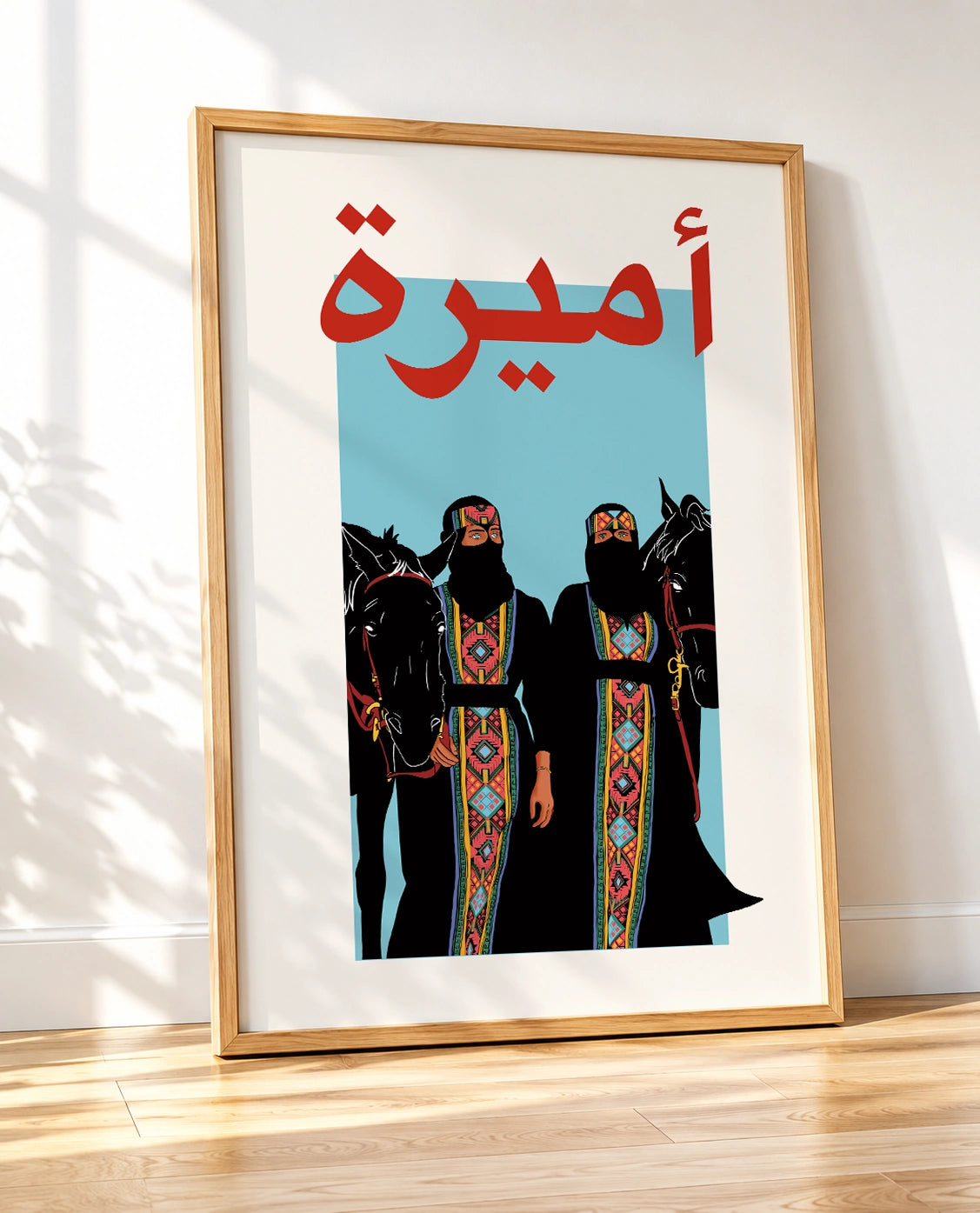 Wooden framed Arab Princesses poster shown at an angle, featuring two women in traditional dress and horses
