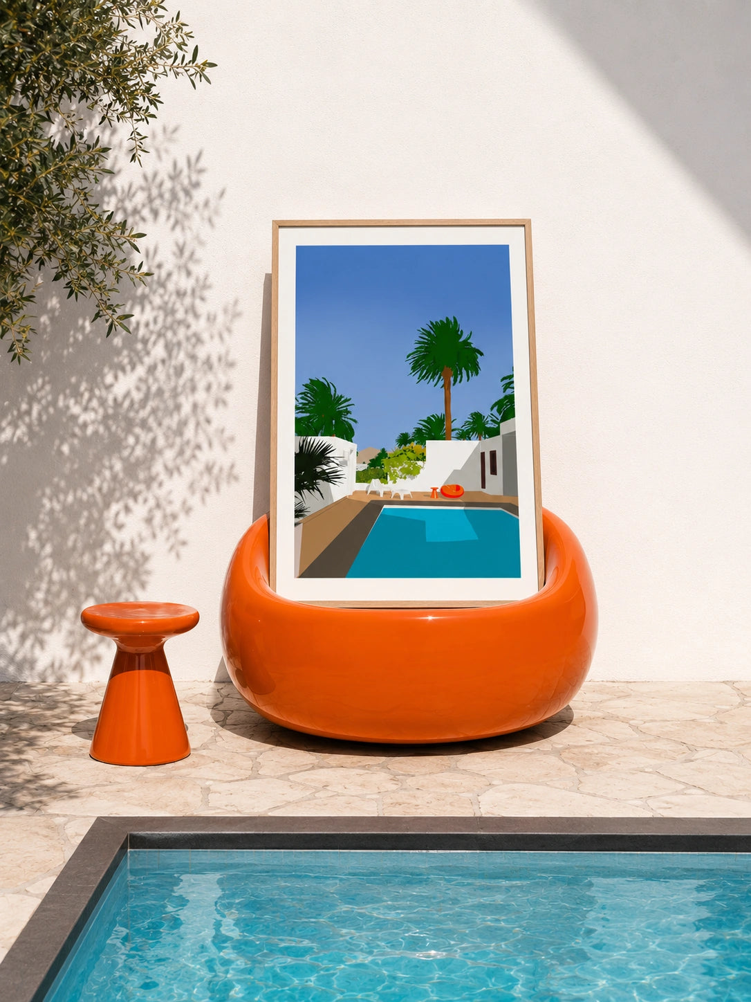 César Manrique House framed poster resting in an orange poolside chair next to a real swimming pool
