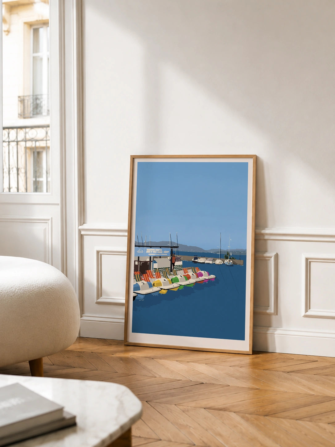 Framed pedal boats lake poster in a Parisian living room with wood paneling and a balcony view

