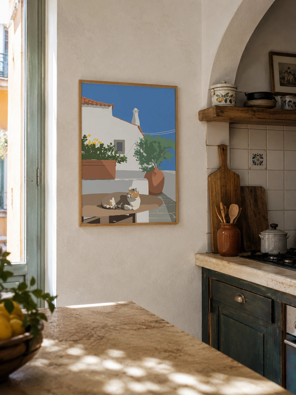 Mediterranean cat framed poster hanging in a rustic kitchen with tiled backsplash and lemons
