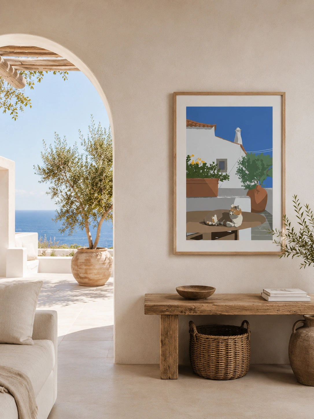 Cat napping on a table framed poster leaning against a wall next to an olive branch vase
