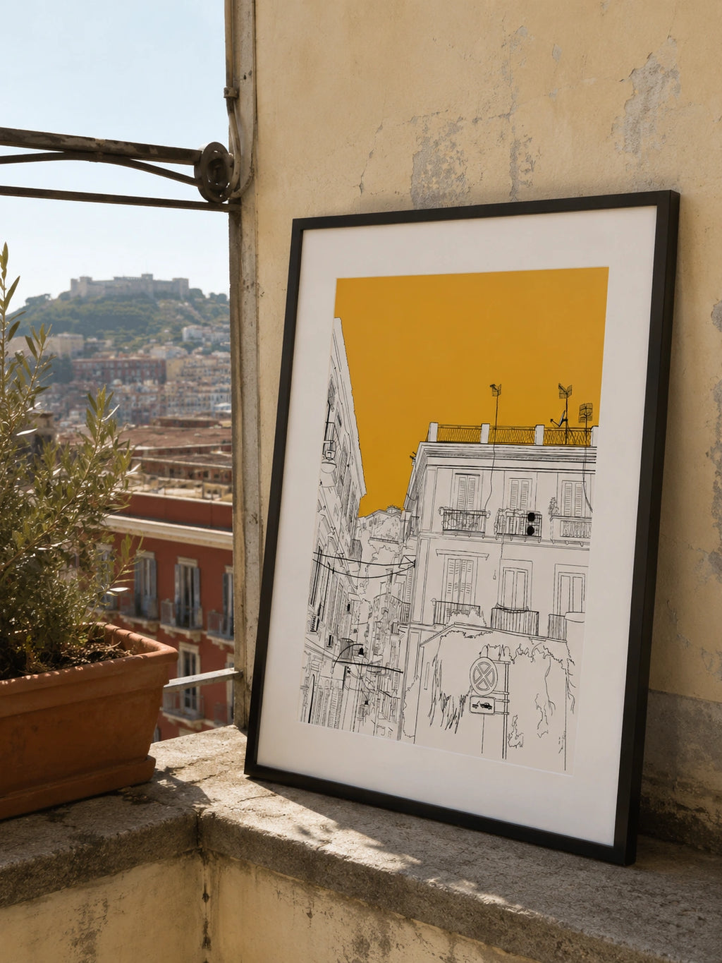 Framed Naples building illustration with orange sky leaning on a stone windowsill overlooking the city
