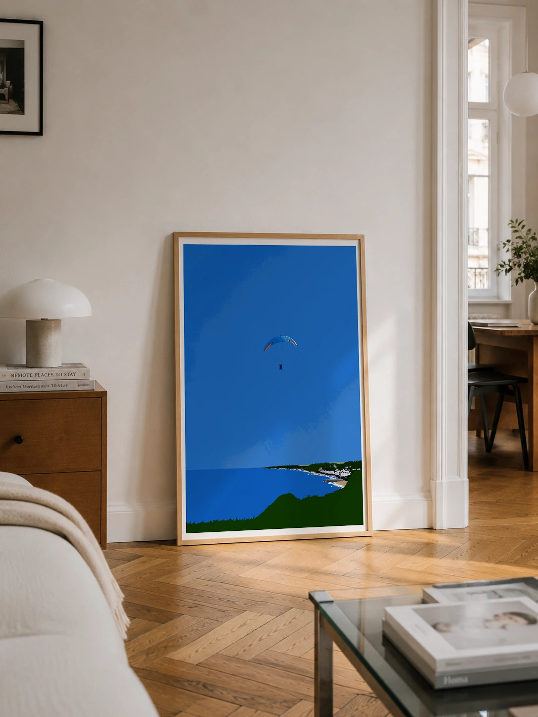 Normandy Cliff framed poster in a Parisian living room with wood flooring and a balcony view
