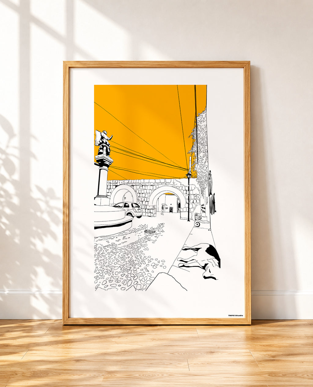 framed Black and white line drawing of a stone archway with a statue on a column, power lines crossing an orange sky, a parked car and a dog resting in the foreground