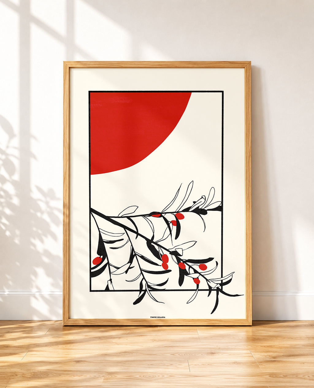 Olive tree branch framed poster with a red sun leaning against a wall in an industrial loft
