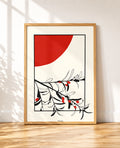 Olive tree branch framed poster with a red sun leaning against a wall in an industrial loft
