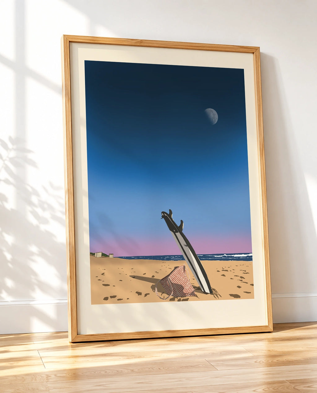 Wooden framed print of a surfboard standing in sand at dusk with the moon visible, shown at an angle
