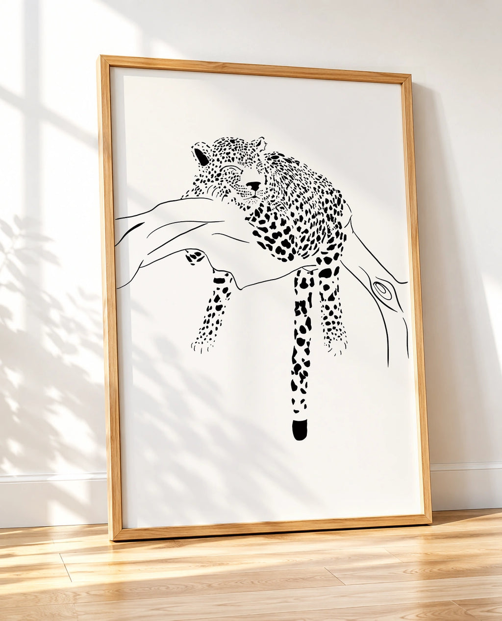 Wooden framed black and white print of a leopard sleeping on a tree branch, shown at an angle
