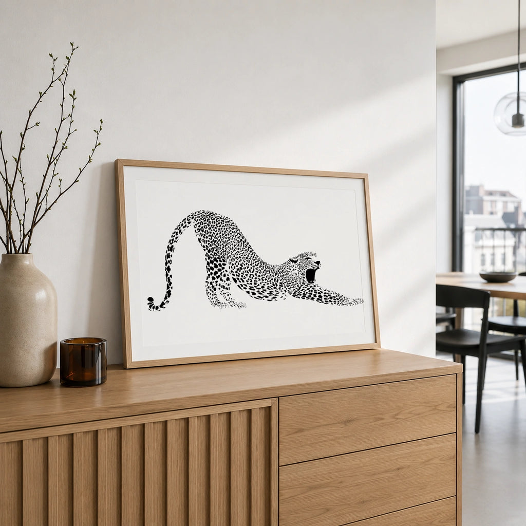 Wooden framed leopard stretching print displayed on a wooden sideboard near a dining room with a view of the city
