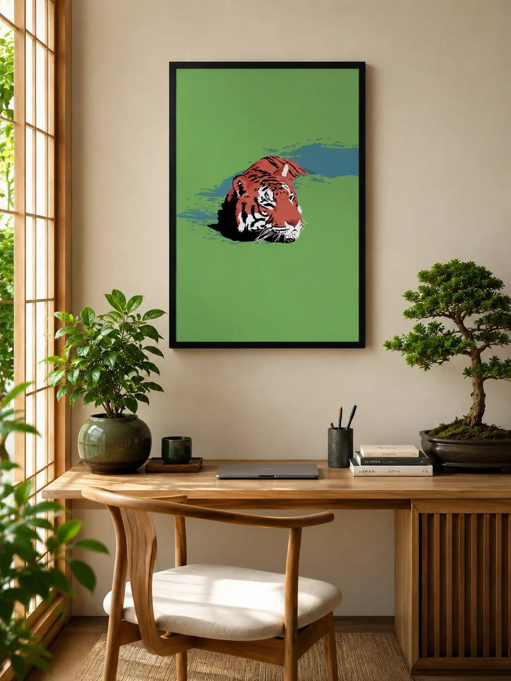 Framed artwork of a tiger on a green background above a wooden desk with plants and office items.