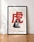 framed Illustration of a red Japanese kanji character for tiger above a black and white tiger's head on a cream background
